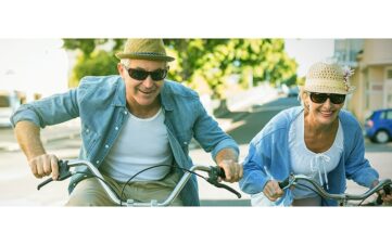 older couple riding bikes, enjoying Total Body Wellness